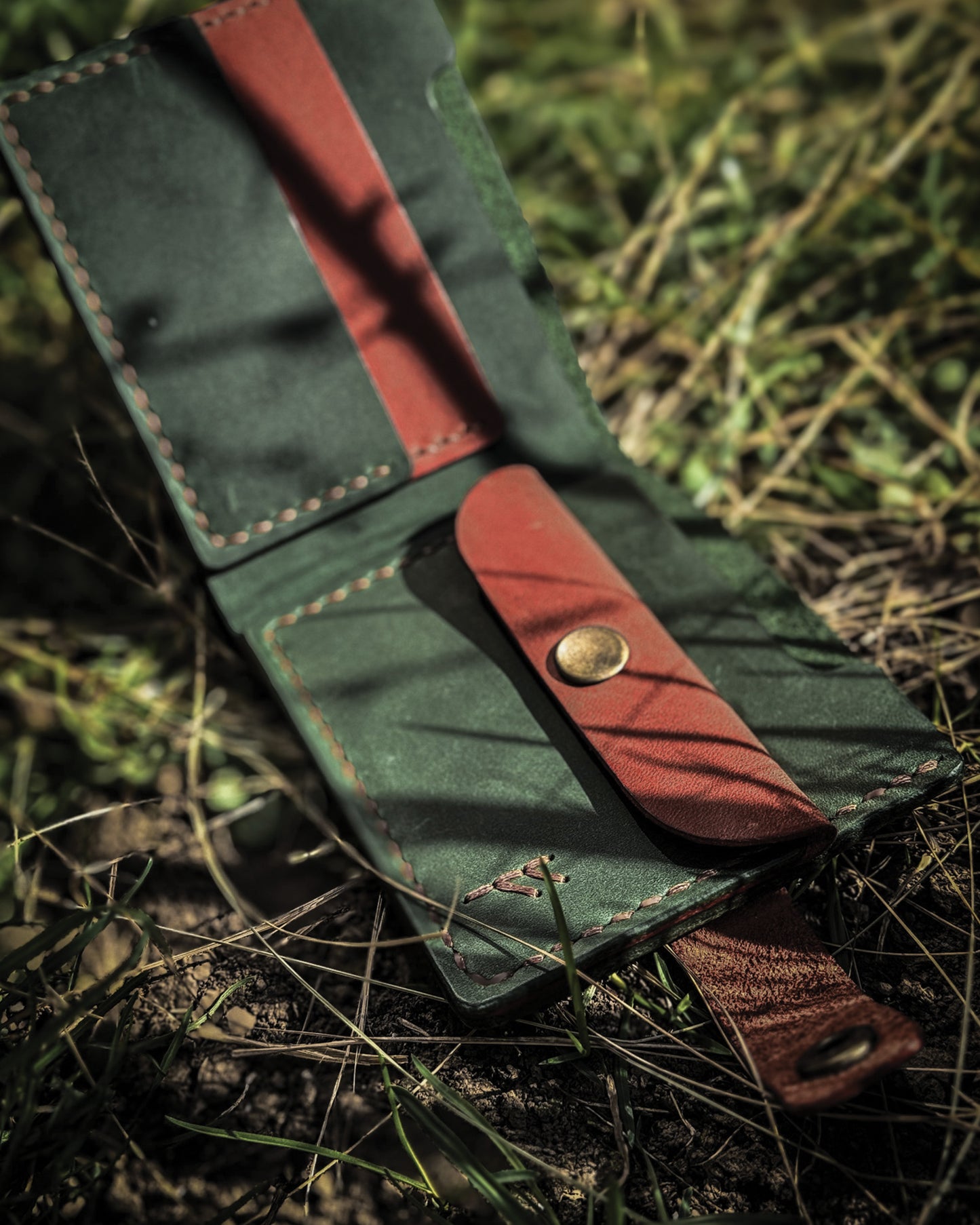 Handmade Viking leather wallets engraved with a custom Bindrune for wealth, prosperity & luck. Features stitched Fehu rune. Available in navy, black & green. Norse mythology meets everyday style.