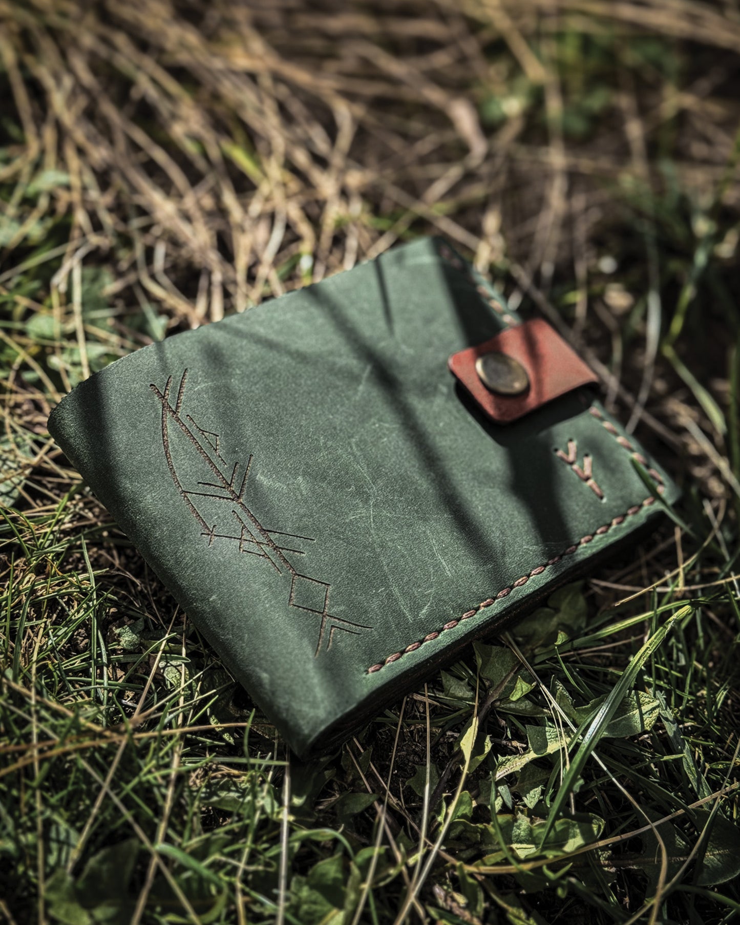 Handmade Viking leather wallets engraved with a custom Bindrune for wealth, prosperity & luck. Features stitched Fehu rune. Available in navy, black & green. Norse mythology meets everyday style.