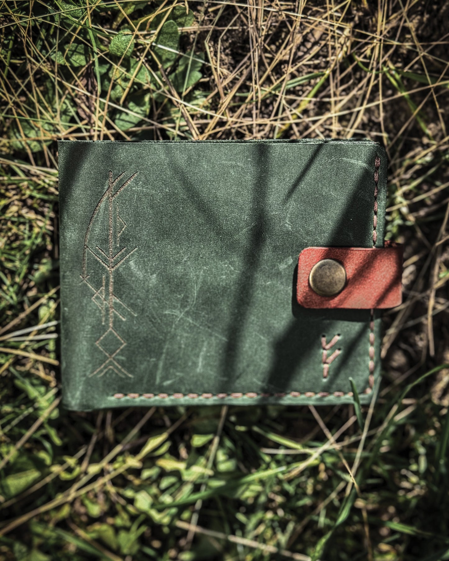 Handmade Viking leather wallets engraved with a custom Bindrune for wealth, prosperity & luck. Features stitched Fehu rune. Available in navy, black & green. Norse mythology meets everyday style.