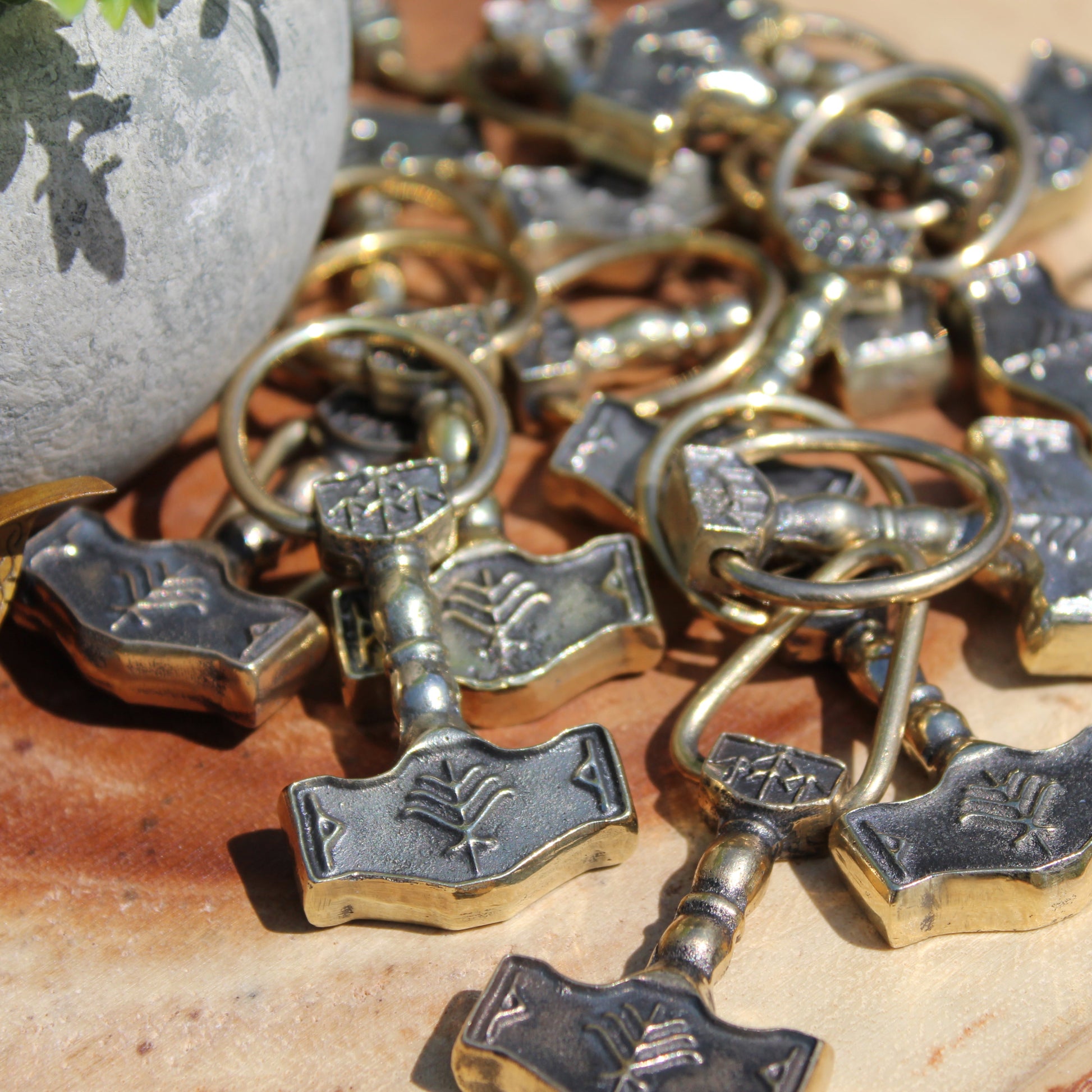 Collection of Thor's hammer keychains on a wooden surface