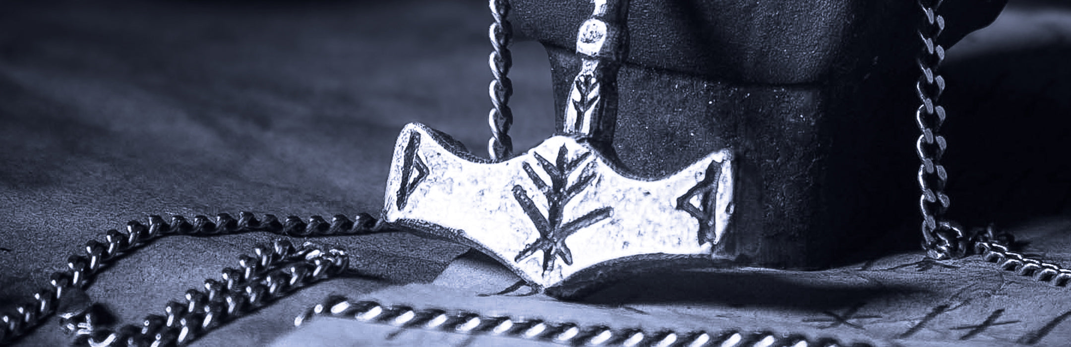 Banner showcasing a handcrafted silver Thor's hammer Mjolnir pendant with a unique Viking protection Bindrune design, symbolizing strength and safety.