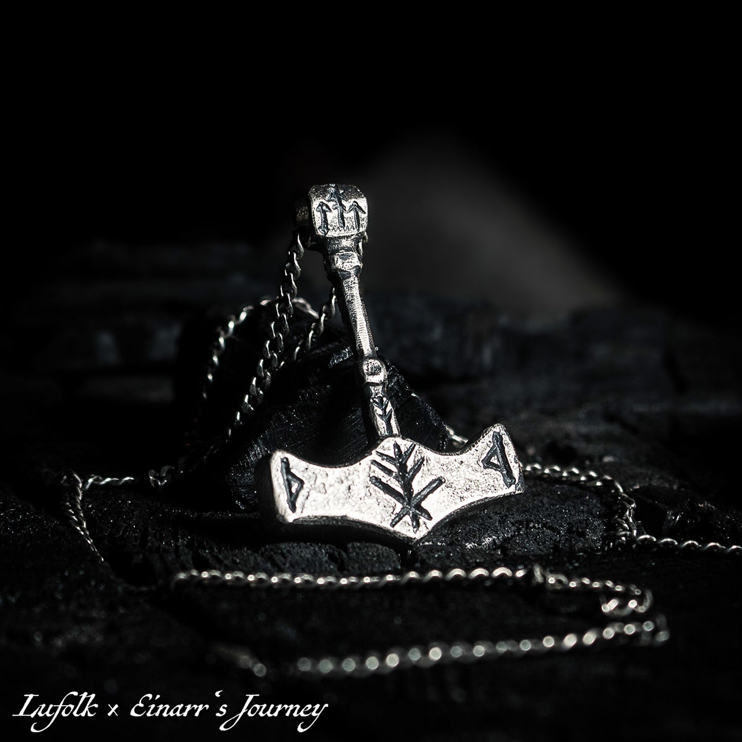 Handcrafted silver Thor's hammer Mjolnir pendant featuring a unique Viking protection Bindrune design for strength and safety.