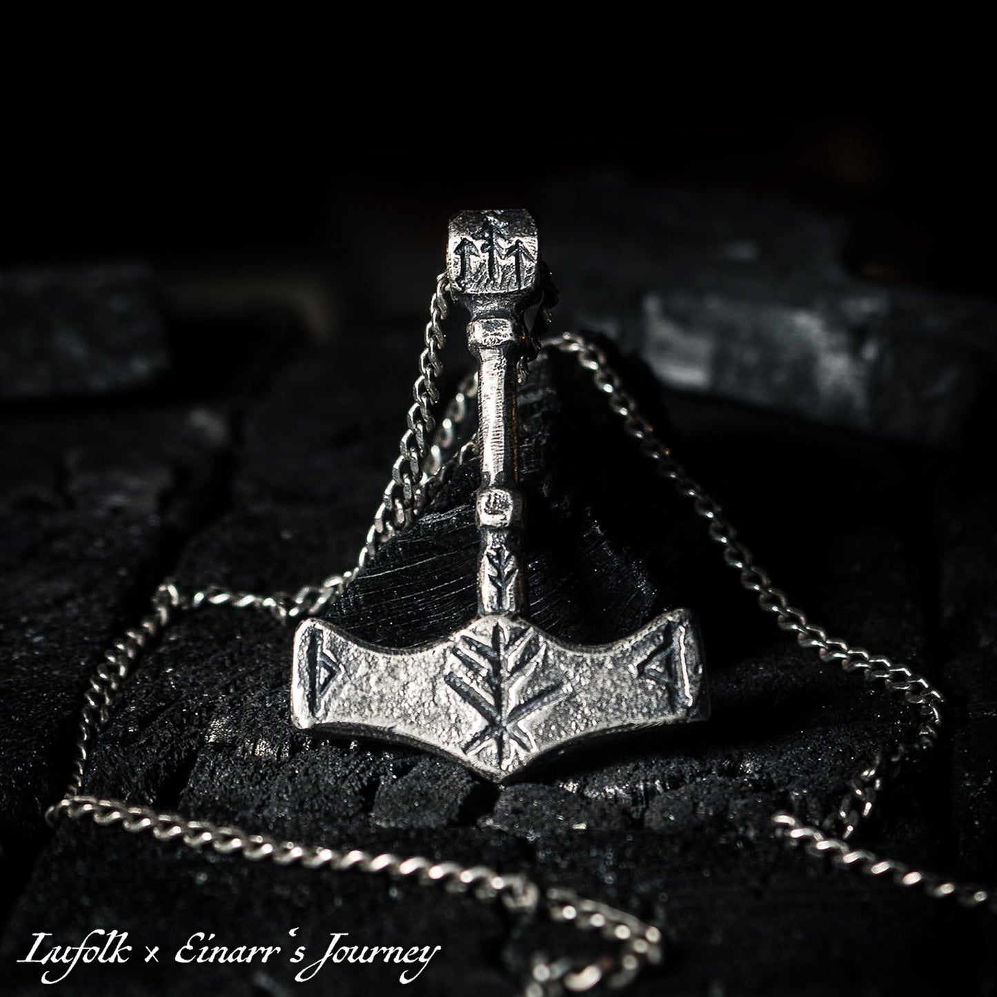 Handcrafted silver Thor's hammer Mjolnir pendant featuring a unique Viking protection Bindrune design for strength and safety.